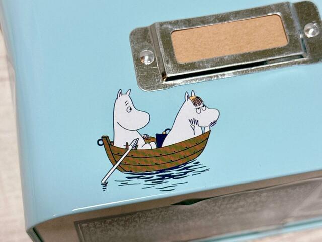 【カルディ/ムーミン ウッドリッド スクエアティン】ボートに乗ったムーミン&スノークのお嬢さん。スノークのお嬢さんはご機嫌ななめな表情もかわいい♪