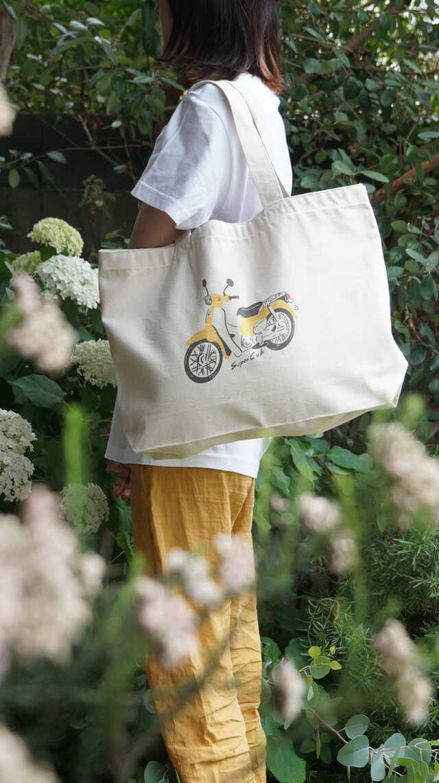 スーパーカブがゆるいタッチで描かれた少しレトロな雰囲気のトートバッグ
