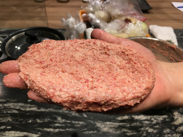 （4）タネができたら4つに分ける。そのひとつを手に取り、左右の手で強く投げ合い、タネに含まれる空気を抜く。これをやや薄い小判型にし、中心を凹ませる