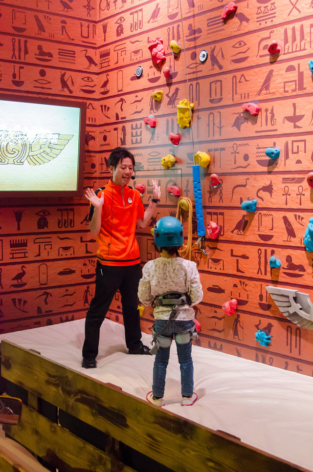 背後のモニターで、車の王国「ガリバー・キングダム」の危機が語られる。登り方の説明を受けたら、いざチャレンジ!|仕事体験テーマパーク「カンドゥー」