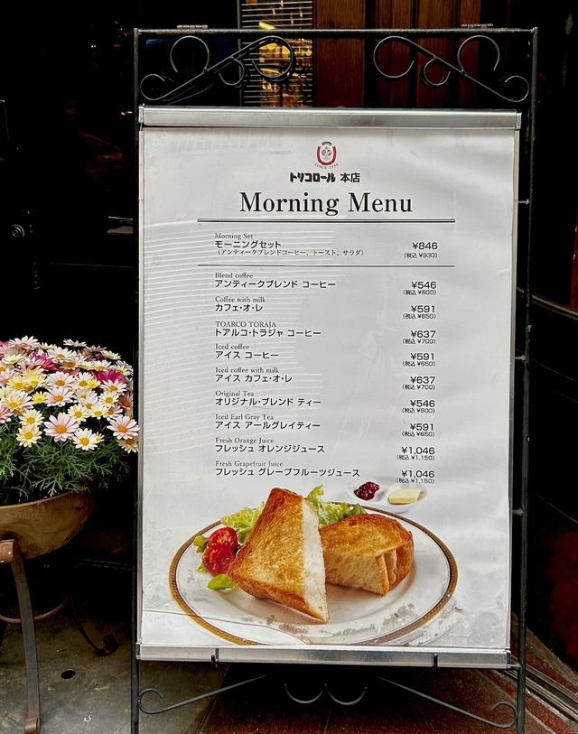 【トリコロール本店】回転ドアの前には。モーニングメニューが掲げられています