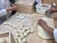 セントラルキッチンから届いた皮を１個１個手切している／東京豚饅