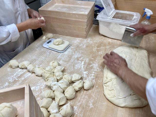 セントラルキッチンから届いた皮を１個１個手切している／東京豚饅