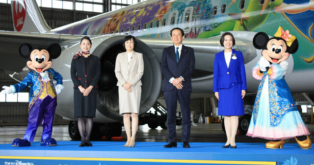 左より、ミッキーマウス、CA氏、日本航空（株）代表取締役社長執行役員　鳥取三津子氏、（株）オリエンタルランド　代表取締役社長（兼）COO　吉田謙次氏、東京ディズニーリゾート・アンバサダー　味方和氏、ミニーマウス【JAL Fantastic Journey Express】