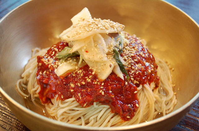 これがスープのない冷麺（咸興式）。韓国人はこの赤いタレが麺にまんべんなくからむようよくかき混ぜて食べる。タレは激辛で、同じ冷麺でもまったく違う料理のようだ