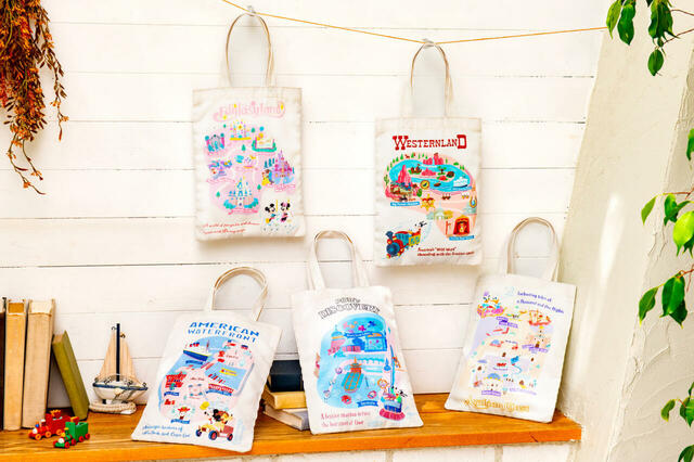 トートバッグ 1,200円｜ミッキーたちが楽しそうに巡っているパークのマップやアイコンをモチーフにしたグッズ｜販売店舗：東京ディズニーランド「グランドエンポーリアム」、東京ディズニーシー「タワー・オブ・テラー・メモラビリア」｜発売日：2024年10月17日（木）