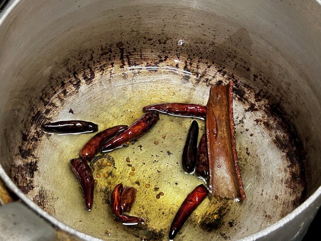 【南インド料理 葉菜hana】●ポイント　トウガラシがこのぐらい黒くなるまで炒める。「辛いのが苦手な人は、このときトウガラシを取り除いてください」