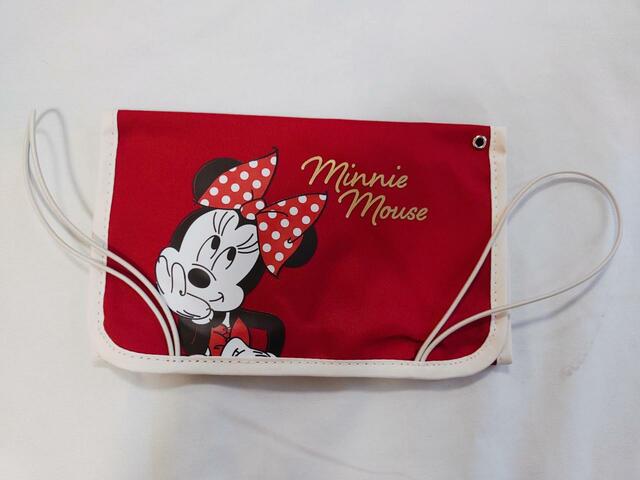 ポーチは赤いカラーに、大きなリボンをつけたミニーマウスのかわいいイラストが描かれています