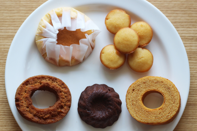 左上から時計回りに、半熟カステラ（150円）、ひとくちはちみつケーキ（150円）、バナナバウム（120円）、ショコラクグロフ（150円）、キャラメルドーナツ（120円）