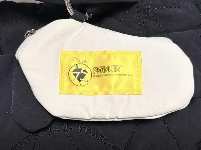 ポーチチャームの背面はピーナッツ75周年を記念したロゴタグ付き