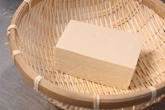 【豆腐の水切り】1．ざるを使う方法。豆腐をパックから出してざるにのせ、5～10分そのまま置いておくだけ。