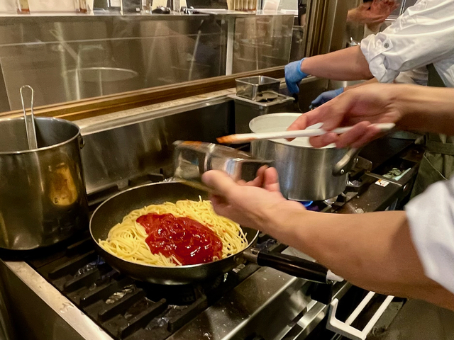 【パーラー矢澤】冷水でしめたパスタをフライパンで炒め、ケチャップとトマトソースをかけます