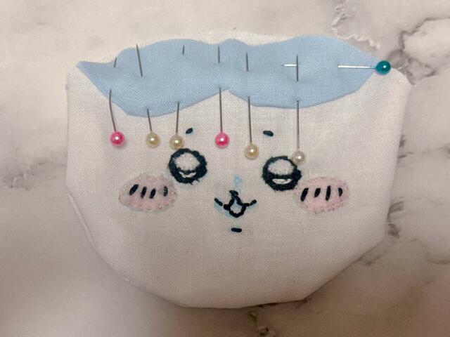 本体にまち針で頭の模様を固定し、とじつけます