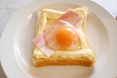 【卵とベーコンのマヨトースト】2．ベーコンをのせ、マヨネーズで作った土手の内側に卵を割り入れる