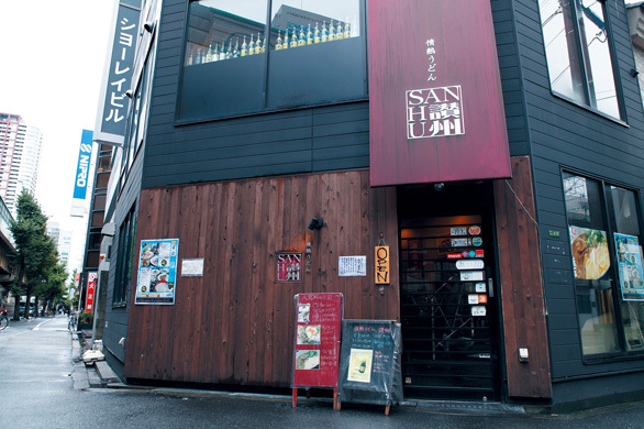 情熱うどん 讃州（大阪・豊崎） 外観　板張りの外壁にエンジ色の店頭幕がトレードマーク。