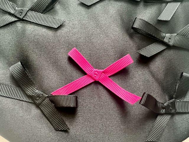 アクセントのピンクリボンは1つ。「乳がん撲滅・早期検査の啓発」の意味が込められています