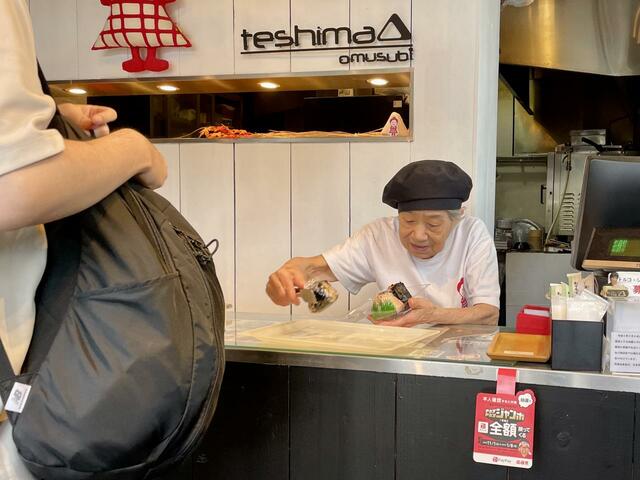 【おむすび てしま】弘子さんはこの壁の奥でおにぎりを作っていることが多いのですが、運がいいと、弘子さんが接客してくれます