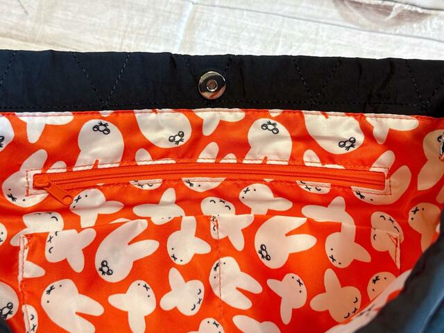 マグネットボタンで開閉する仕様。内側にはファスナーポケット1つと区切りポケット2つがついています！