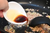 【ボンカレー公式アレンジレシピ「マーボーカレー」】豚ひき肉にしっかり火が通ったら、しょうゆを加える