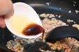 【ボンカレー公式アレンジレシピ「マーボーカレー」】豚ひき肉にしっかり火が通ったら、しょうゆを加える