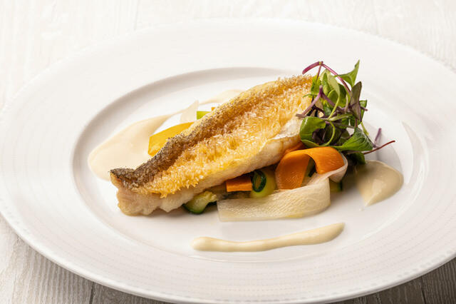 「甘鯛の鱗焼き 白ワイン風味のソース」＜期間：2025年7月1日～8月31日＞【“マンゴーとココナッツのケーキ”や“スペシャルなかき氷”も登場！オリエンタルホテル広島「夏のデザートブッフェ付きランチ」開催！】