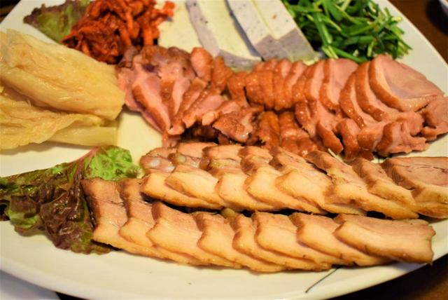 ソウルのロッテワールドタワー内にあるレストランのテジポッサム。豚肉（手前）だけでなく鴨肉（中央）も。白キムチ、切り干し大根のキムチが添えられている