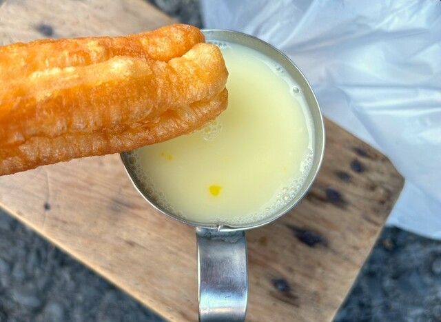 【台湾食べ歩きの旅 #19】杏仁茶（25元）に10元をプラスすると、卵を落としてくれる。杏仁茶は熱々なので、生の黄身を落としたら素早く混ぜると飲みやすい