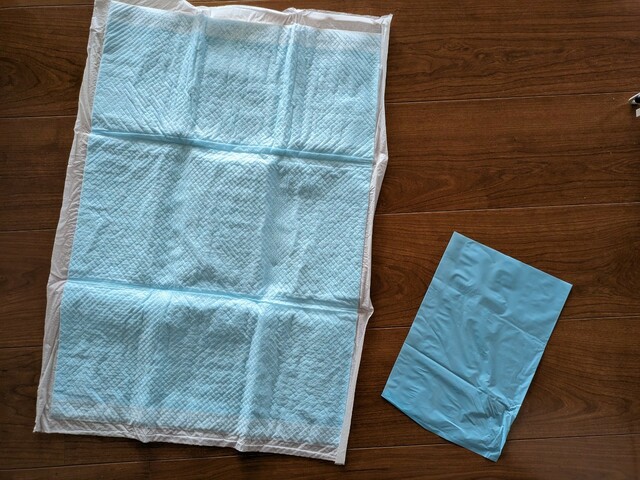 【ダイソー ペット用消臭ポリ袋 SS】ワイドタイプのペットシーツと比較した大きさ。小さくたためばペットシーツも密封できました