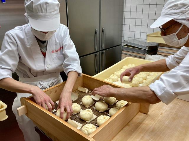並べた経木に包んだばかりの豚饅をおいていく／東京豚饅