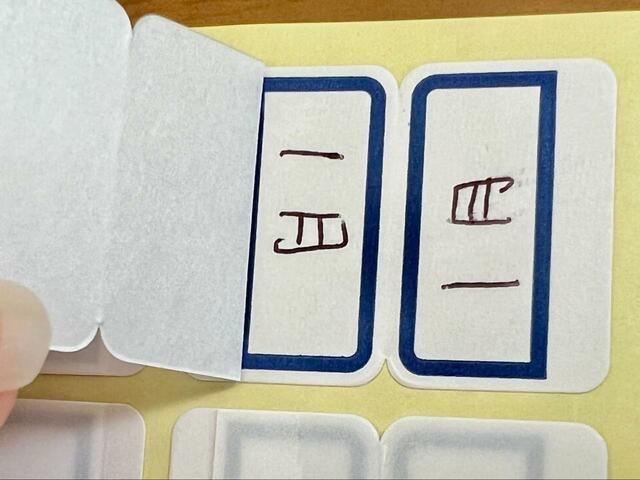 【ダイソー ラミネートインデックス 中 156枚入】はくり紙とラミネートシールをめくり、文字を書いてはくり紙を剥がして貼り付けるだけ