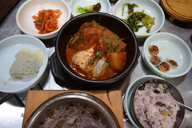 『トンガン・ミンムルコギ』のごはん（写真手前左）は、熱々の釜で出てくる。これをステンレスの器（写真手前右）に移し、釜にはお湯を注いでお茶代わりに飲む