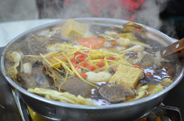 高雄「水源羊肉爐」の骨付きラム肉の当帰風味鍋。クコの実やショウガもたっぷり入る薬膳鍋だが臭みは少ない。豆腐やキャベツなどの具も入る