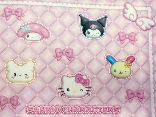 【サンリオキャラクターズ当りくじ】「21．ファイルホルダー／ピンク」ファイルホルダー表紙上段に登場しているキャラクターは、ハローキティ、マイメロディ、クロミ、はなまるおばけ、ウサハナ！