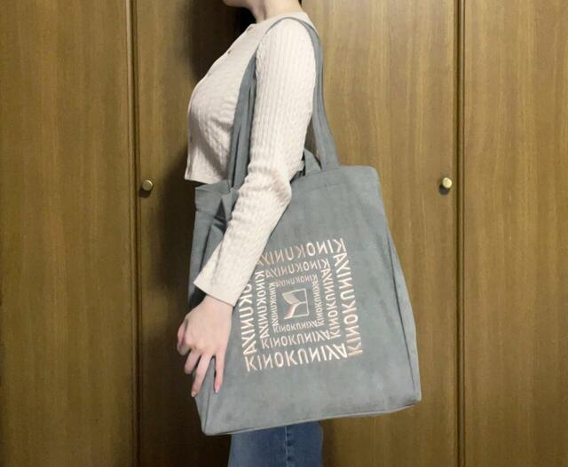 身長155cmの筆者が実際に持ってみました。ノートPCやペットボトルが入っていますが、底部がたわんでいないの、わかりますか？