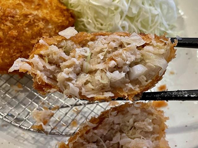 【豚肉専門料理店とんかつのり】豚肉の他、玉ねぎやキャベツが入っている