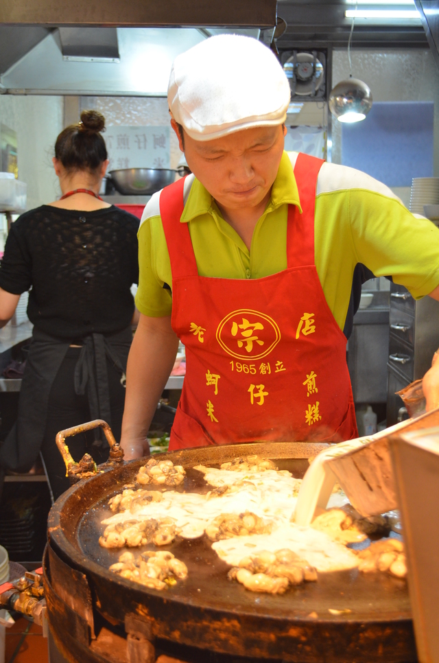 『圓環邊蚵仔煎』の行列に並んでいる間は蚵仔煎焼きのパフォーマンスを楽しもう。このお兄さん、カメラを向けるとがぜんハッスルし出した