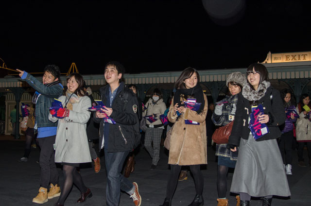 手には、サンクスデー専用のTODAYと、サンクスデーデザインのマフラータオル ©Disney