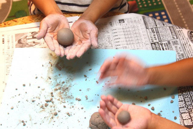 丸めてだんごにし、両手の中でころころと転がし丸くします。2人とも上手にまるいおだんごをつくりました。※この時、だんごの表面をを凹凸のないきれいな丸にしておくと、よりピカピカのだんごにすることができます。 ※このタイミングで下敷きを洗っておくとあとで便利です。