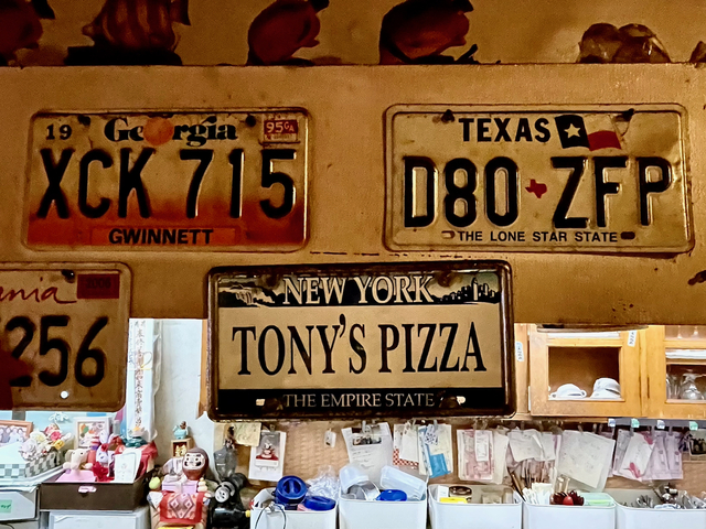 【トニーズピザ】アメリカのナンバープレートが店内に飾ってある。店のナンバープレートは、どこかに作ってもらったダミー