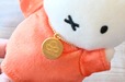 【誕生70周年記念 ミッフィー展/オリジナルマスコット レッド ¥2,860】胸元の70周年の記念チェーン。裏は『うさこちゃんとたれみみくん』に登場するお花のイラストになっています