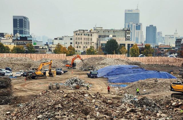 世運商街の北端のビルの歩行路から東側を望む。かつての工場群は撤去され更地になっている。いずれここにも高層ビルが建つだろう。右手の向こうに見える高層ビルは東大門市場の斗山タワー