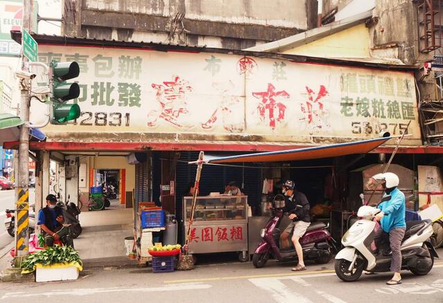 【台湾食べ歩きの旅 #7】羅東民生市場の周辺には朝ごはん屋が多い。古い布屋の看板の下にもち米おにぎりの店を見つけた。バイクから降りずに注文する人も
