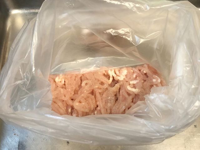 【鶏肉団子スープ】鶏ひき肉に塩こしょうをして袋の上から揉み込む