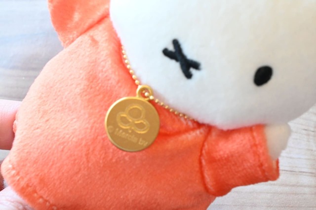 【誕生70周年記念 ミッフィー展／オリジナルマスコット レッド ￥2,860】胸元の70周年の記念チェーン。裏は『うさこちゃんとたれみみくん』に登場するお花のイラストになっています