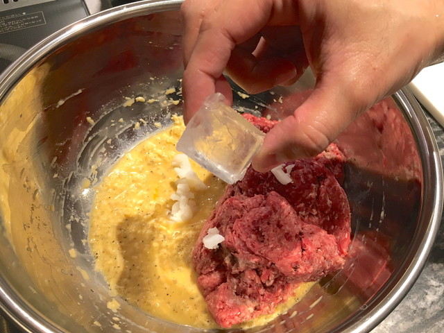 （2）牛ひき肉、混ざりやすいように細かく切った牛脂、氷を入れて、こねる。肉と牛脂がよくなじむように、牛脂を手でつぶしながら混ぜる