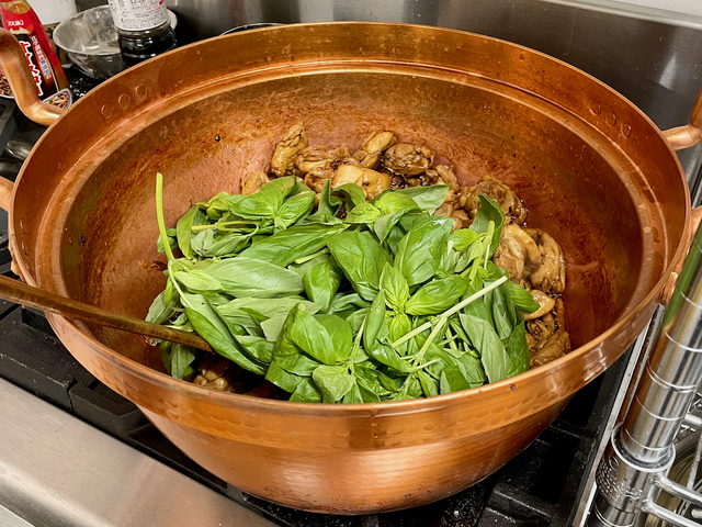 【33】炒め終えた鶏肉にドカン！とバジルを入れ、バジルの香りを鶏肉に移す。これが美玲さんの三杯鶏だ