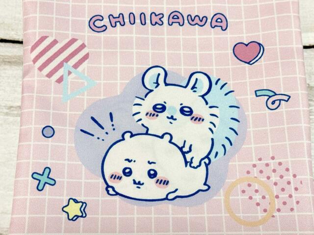 【ちいかわ DAISO限定デザイン】「巾着 ちいかわ」フロントはピンクのチェックに、ちいかわの上にモモンガが乗ったイラスト入り。ちいかわの嫌そうな表情とモモンガの堂々としたイラストがサイコー！