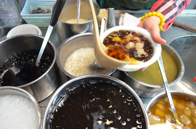 「あんたも毎日食べれば若返るよ」と言いながら豆花をよそう『城中豆花』の女将