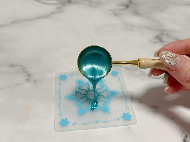 スプーンからワックスピルをシリコンマットに垂らします