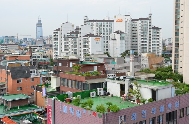 筆者の住むソウルの東のはずれ、江東区千戸洞（命名、ソウルの北千住）。雑居ビルの屋上に建っているのがオクタッパンだ。室外機が取り付けられていることから、そこに人が住んでいることがわかる。